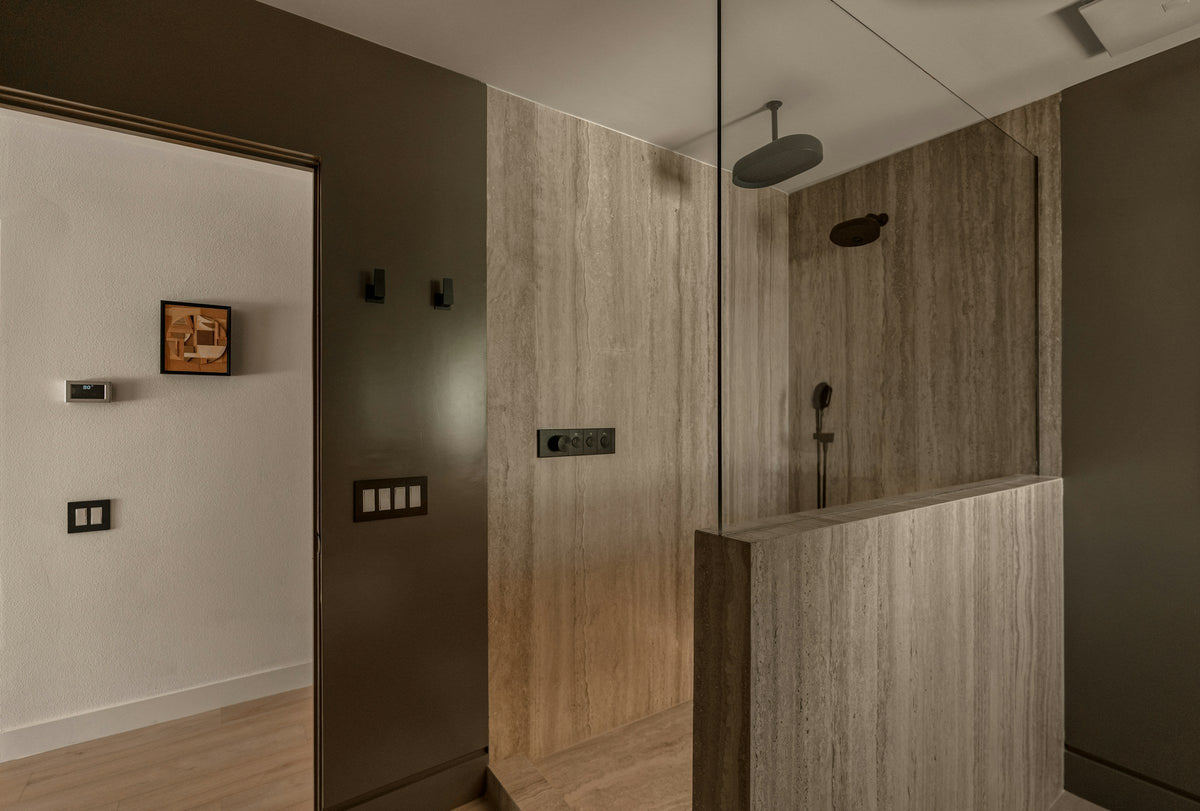 Modern walk-in shower with rain shower head and stone-look walls
